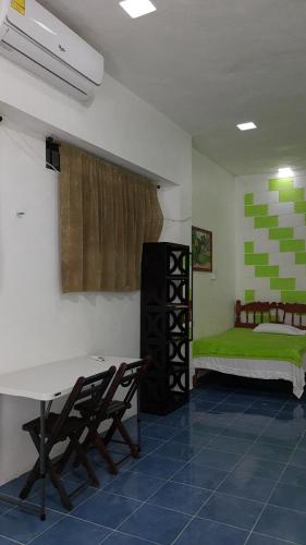 um quarto com uma cama, uma mesa e cadeiras em Departamento en la 43 em Oxkutzcab