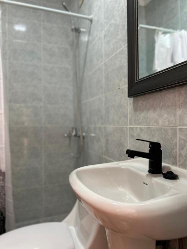 a bathroom with a sink and a shower with a mirror at Casa Di Patti B & B in Santiago