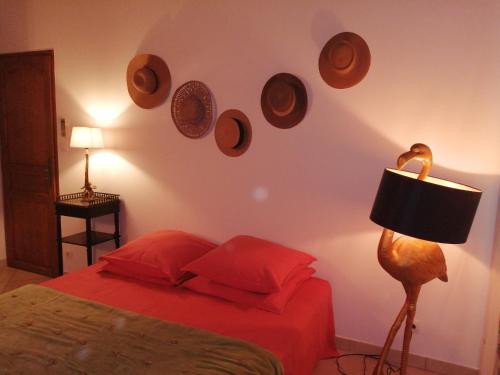 Un dormitorio con una cama y platos en la pared en Chambre d'hôtes Les moutons bleus, en Le Tronquay