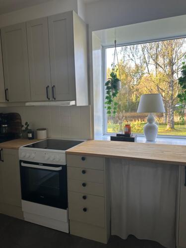 a kitchen with a stove top oven next to a window at Prästgården in Norberg