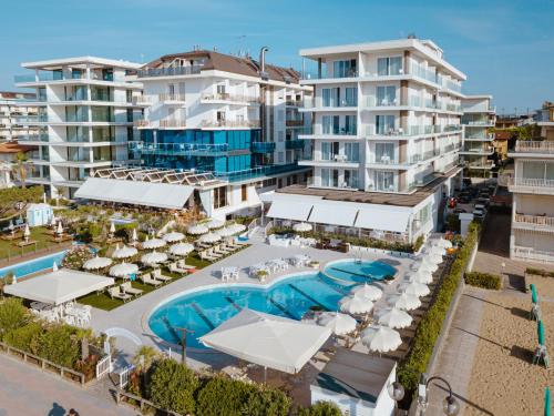 eine Luftansicht eines Resorts mit Pool und Gebäuden in der Unterkunft Hotel Galassia Suites & Spa in Lido di Jesolo