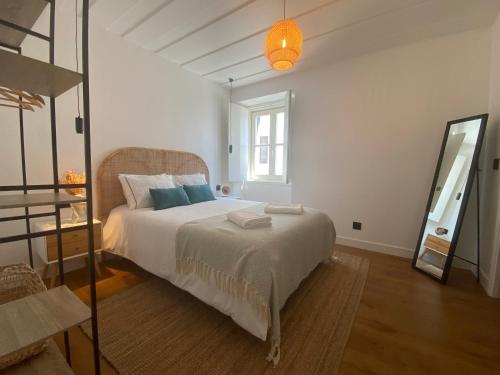 een slaapkamer met een bed en een spiegel bij Grândola Suites - Suite Henrique in Grândola