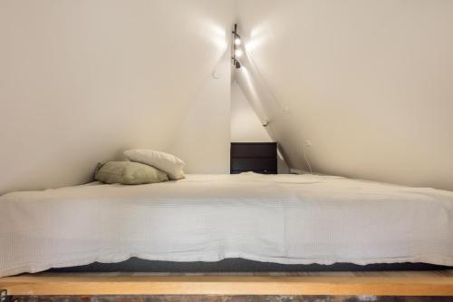 a bedroom with a white bed with a lamp at Charming Loft City Center in Copenhagen