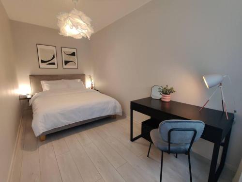 een slaapkamer met een bed, een bureau en een stoel bij Super asukohas modernne korter! in Pärnu