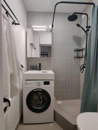 een badkamer met een wasmachine en een wastafel bij Super asukohas modernne korter! in Pärnu
