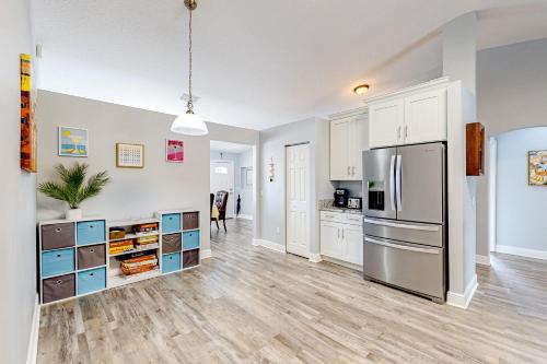 a kitchen with white cabinets and a stainless steel refrigerator at Never Ending Summer in Summerfield