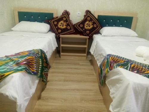 two beds sitting next to each other in a room at Elita House Samarkand in Samarkand