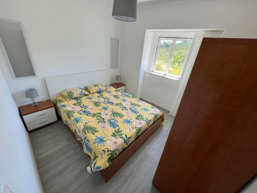 a small bedroom with a bed and a window at A Casa da Azenha in Sertã