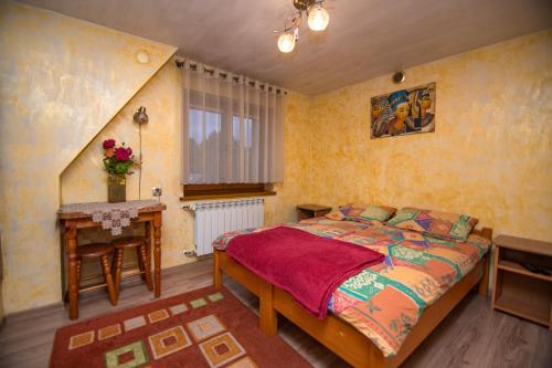 ビャウカにあるLimba pod Kotelnicąのベッドルーム1室(ベッド1台、テーブル、窓付)