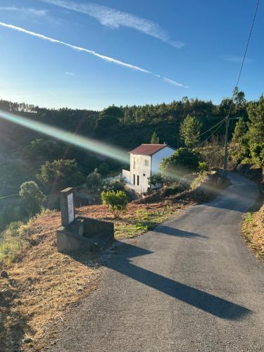a road with a building on the side of a hill at A Casa da Azenha in Sertã