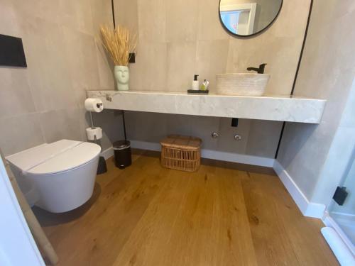 bagno con lavandino, servizi igienici e specchio di Grândola Suites - Suite Loft a Grândola