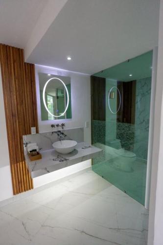 ワウチナンゴにあるHOTEL FORESTの洗面台とガラスのシャワーを備えたバスルーム