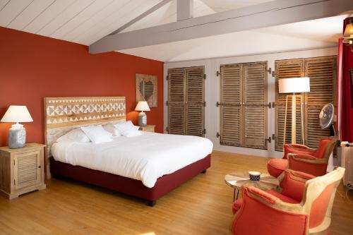 um quarto com uma cama grande e 2 cadeiras em La Martinoise Garden em Saint-Martin-de-Ré