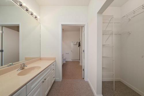 a white bathroom with a sink and a mirror at City-View Chicago 3-BR Rooftop in Chicago