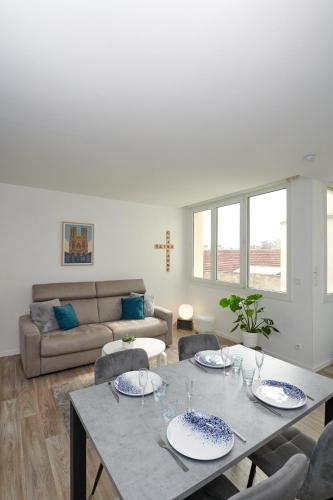 un salon avec une table, des chaises et un canapé dans l'établissement Hyper-Centre /4 personnes/ Cathédrale / Ascenseur, à Reims