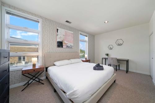 a bedroom with a bed and a desk and windows at City-View Chicago 3-BR Rooftop in Chicago