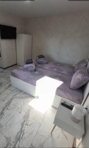 sypialnia z dużym łóżkiem z fioletową pościelą i poduszkami w obiekcie Студио Ава 2 w mieście Sliwen