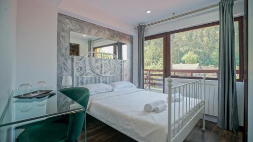 Vila 7 Izvoare في ساتشيلي: غرفة نوم بسرير ابيض ونافذة كبيرة