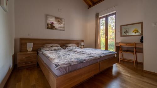 1 dormitorio con cama, escritorio y ventana en Villa Arton heated swimming-pool, en Žminj