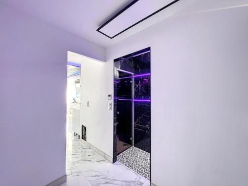 a hallway with a glass door with purple lighting at 240 Magnifique Appart Deluxe Hammam vue mer in Cap d'Agde