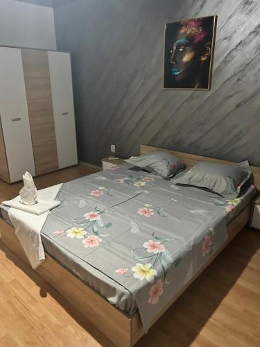 - un lit avec une couverture bleue et des fleurs dans l'établissement Apartament regim hotelier 1 camera, à Galaţi
