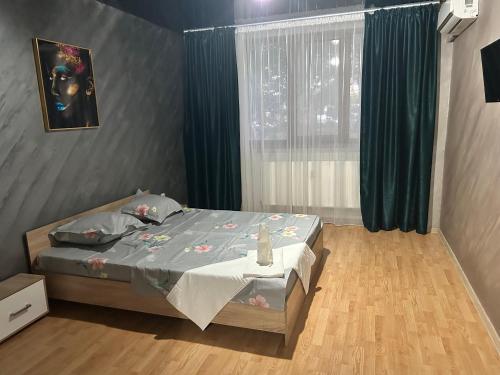 - une chambre avec un lit et une fenêtre avec des rideaux verts dans l'établissement Apartament regim hotelier 1 camera, à Galaţi