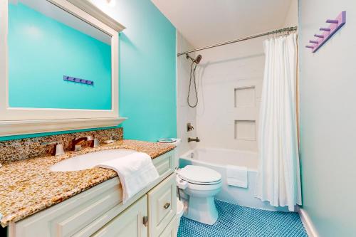 Un baño con lavabo, inodoro y bañera. en Cap'n Stilts, en Hatteras