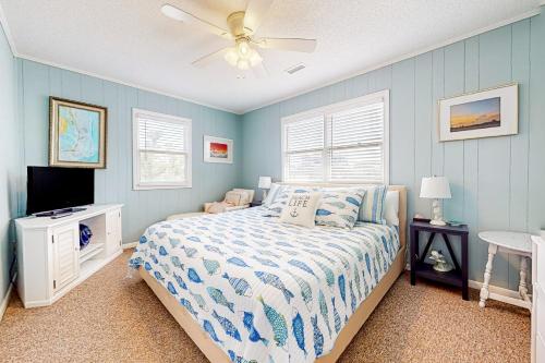 1 dormitorio con 1 cama y ventilador de techo en Cap'n Stilts, en Hatteras