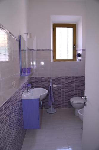 a bathroom with a sink and a toilet at B&B Le Rose in Olbia