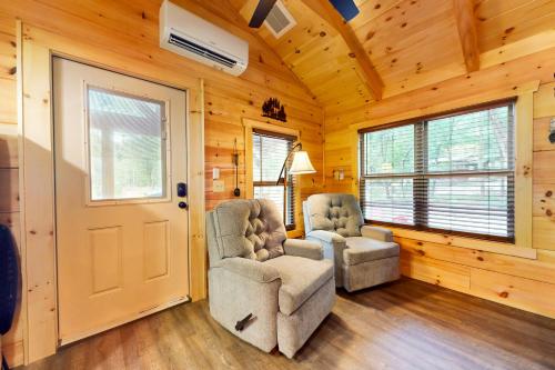 two chairs and a door in a room with wooden walls at The Bear Cabin in Franklin
