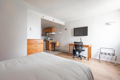 a bedroom with a bed and a desk with a computer at Hotel les Suites Labelle in Montreal