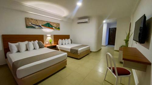 Habitación de hotel con 2 camas y escritorio en Sunsol Isla Caribe en El Agua