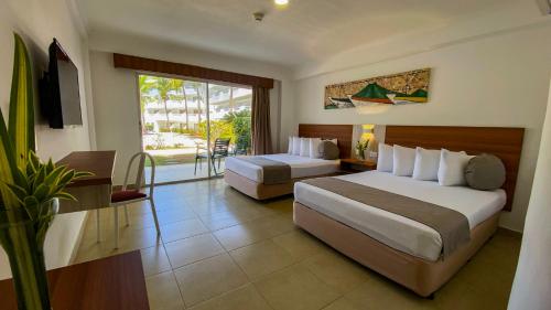 a hotel room with two beds and a balcony at Sunsol Isla Caribe in El Agua