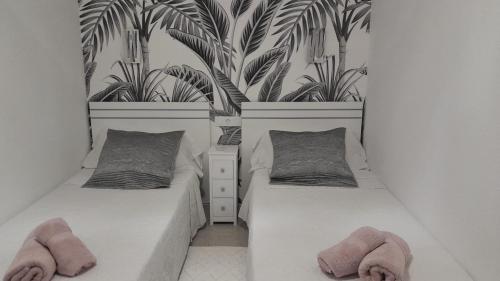 two beds in a room with two potted plants at TAMARAN (ENTRE YUMBO ET CITA) in Playa del Ingles