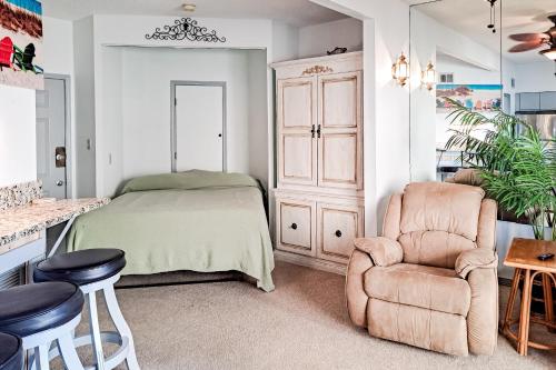 a bedroom with a bed and a chair at Lei Lani Village 103 in Orange Beach