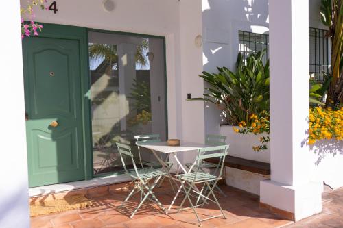 een tafel en stoelen op een veranda met een groene deur bij Apartamentos Brillante 156 in Córdoba