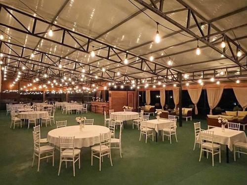 Großes Zimmer mit Tischen, Stühlen und Beleuchtung in der Unterkunft Hotel Park in Negotino