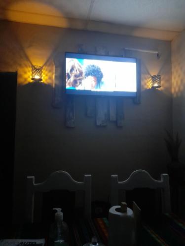 - une télévision sur un mur dans une chambre sombre et éclairée dans l'établissement Alojamiento Salvador, à San Salvador de Jujuy