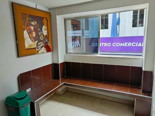 a bench in a public restroom with a window at Hotel Marat suite in Medellín
