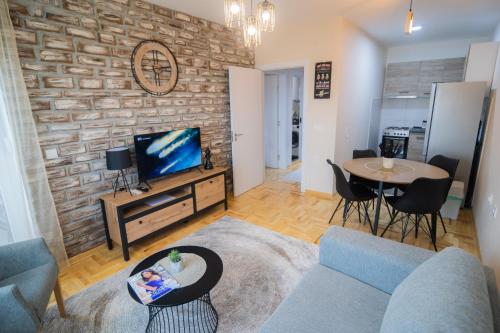 a living room with a couch and a tv and a table at Apartman Iris in Niš
