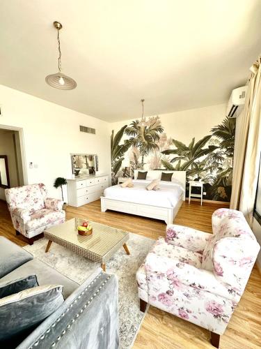 a living room with a bed and two chairs at Casa Soraya in Dubai