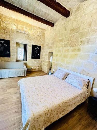 a bedroom with a large bed in a stone wall at Town House 91 in Victoria