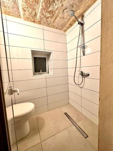 Town House 91 في فيكتوريا: حمام مزود بمرحاض وجهاز تلفزيون معلق على الحائط