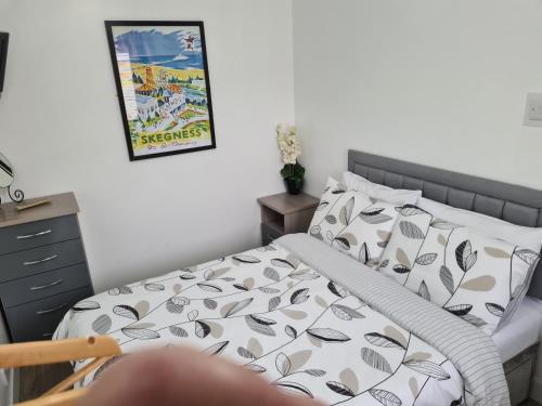 sypialnia z łóżkiem i zdjęciem na ścianie w obiekcie North Parade Holiday Apartment 35 Sea View Road Skegness PE25 1BS w Skegness