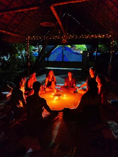 a group of people sitting around a table at night at Jambavan Arts Sanctuary in Varkala
