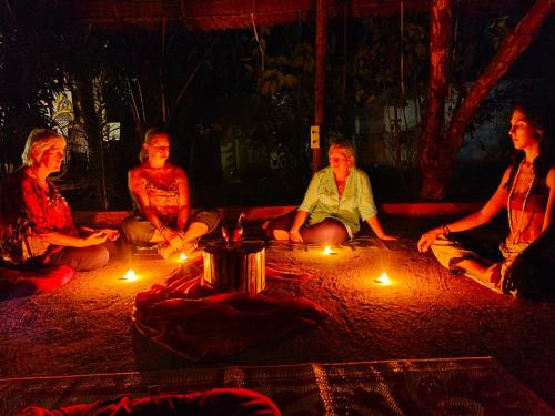a group of people sitting around a circle with lights at Jambavan Arts Sanctuary in Varkala