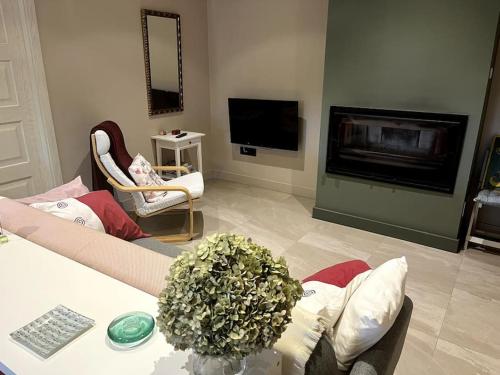 ein Wohnzimmer mit Couch und Kamin in der Unterkunft La casita del bosque in Lugo