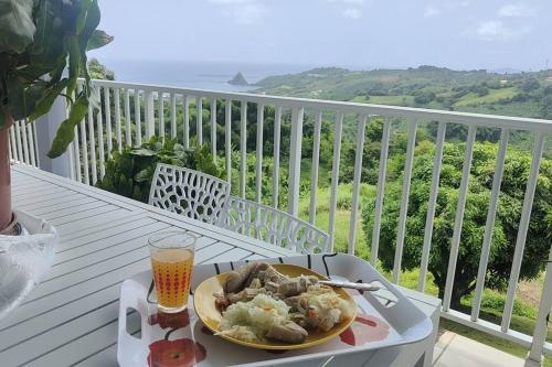 een bord eten op een tafel op een balkon bij Bel appartement de 250 m² dans un coin de paradis in Marigot