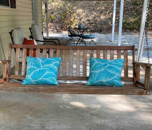 a wooden bench with blue pillows on a porch at Cabin in Mathias