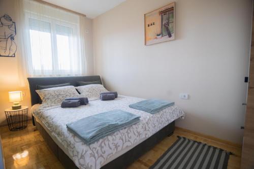 a bedroom with a bed with blue towels on it at Apartman Iris in Niš